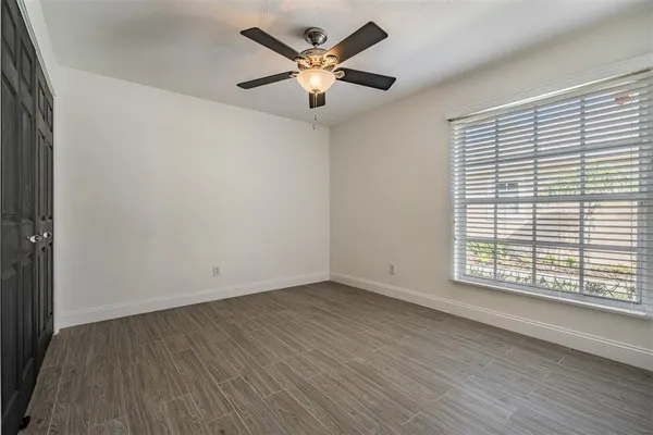 an empty room with wooden floor and windows