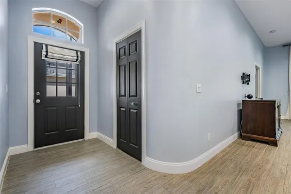 a view of a hallway with wooden floor and a bathroom