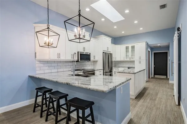 a large kitchen with kitchen island a large island in the center and stainless steel appliances