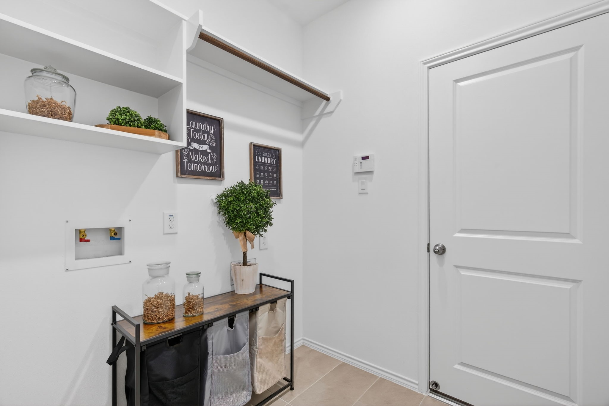 31731 Redbud Blossom Lane Spring, TX 77386 - Photo 15 of 38 This photo shows a well-organized laundry room. It features open shelving and a rod for hanging clothes.