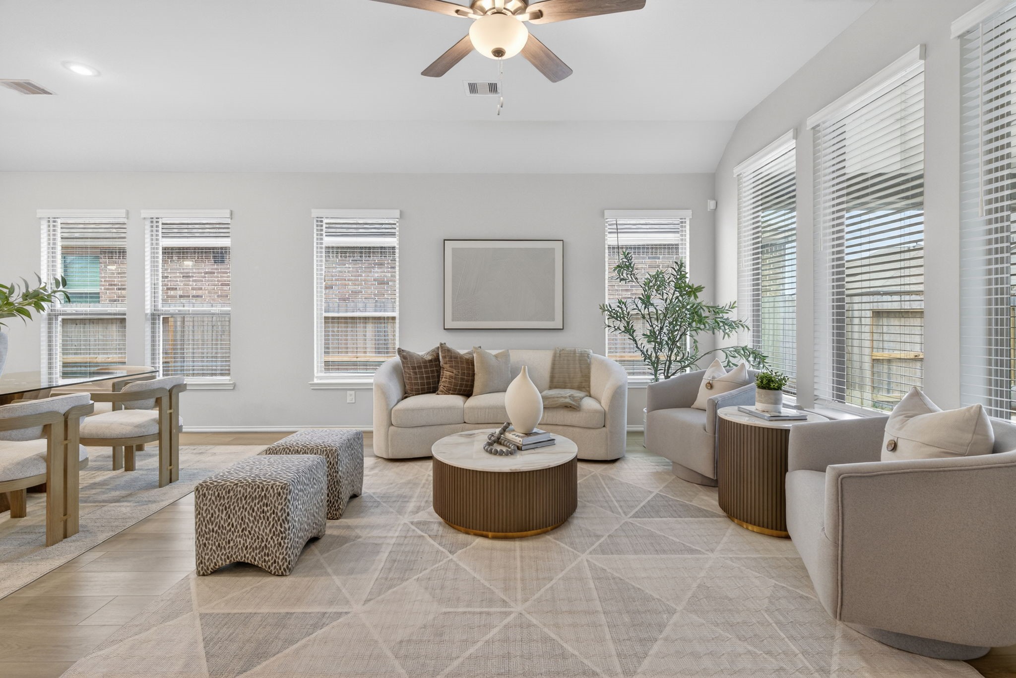 31731 Redbud Blossom Lane Spring, TX 77386 - Photo 20 of 38 This inviting living room features abundant natural light through large windows. The open layout flows seamlessly into the dining area, creating a spacious and airy atmosphere.