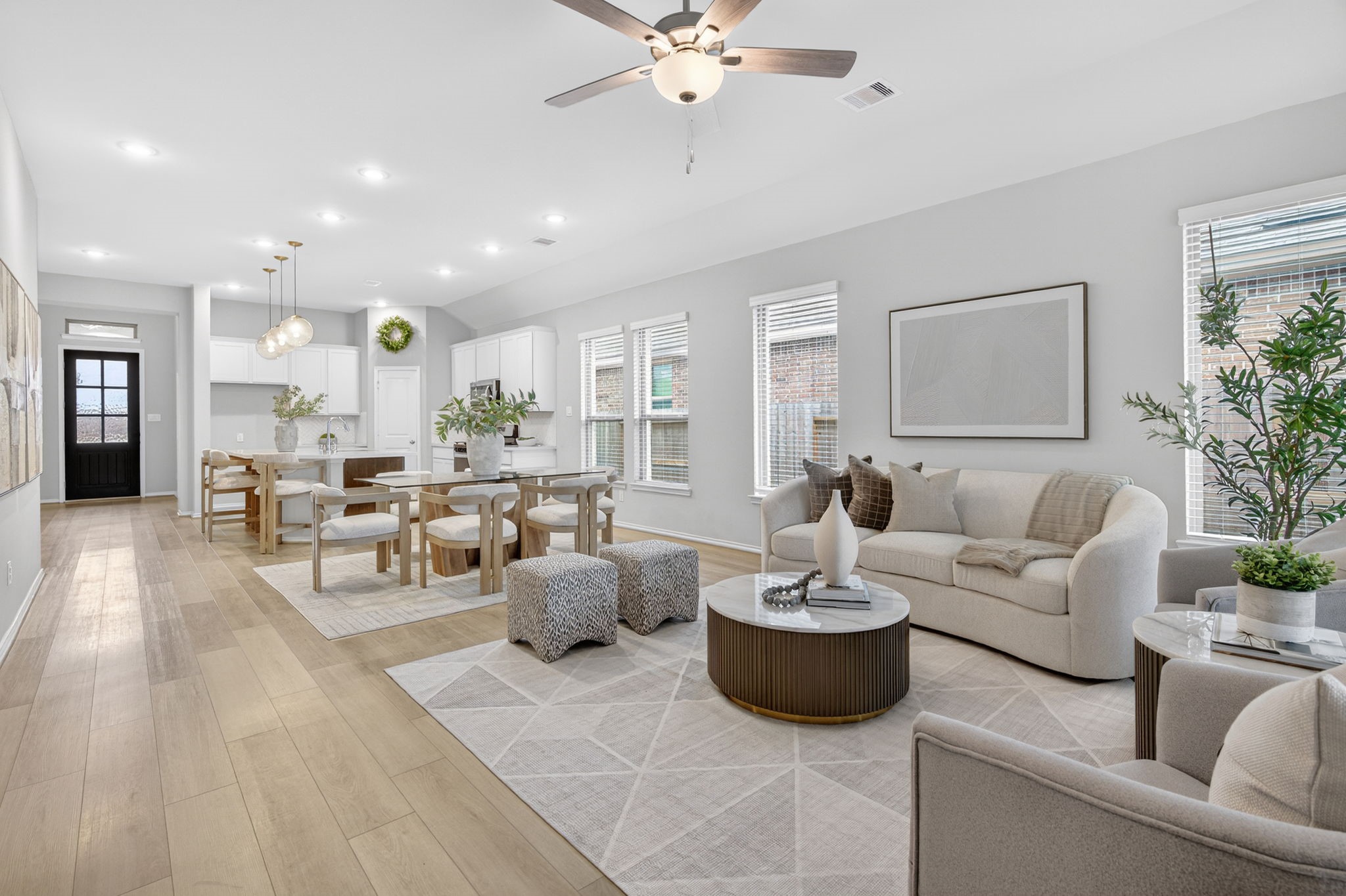31731 Redbud Blossom Lane Spring, TX 77386 - Photo 21 of 38 This photo showcases a bright, open-concept living and dining area with modern decor. The kitchen is visible in the background, enhancing the spacious feel.