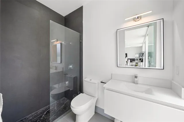 a bathroom with a sink toilet a mirror and shower