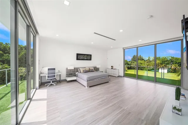 a bedroom with furniture and a large window