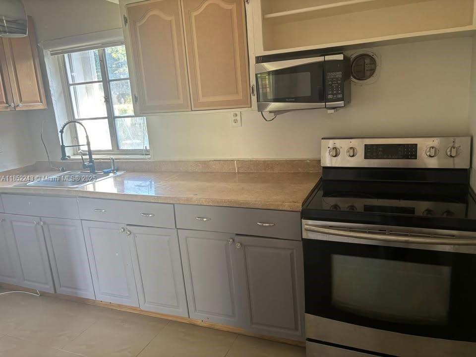 5740 Southwest 60th Street Miami, FL 33143 - Photo 5 of 7 a kitchen with granite countertop white cabinets and a stove top oven