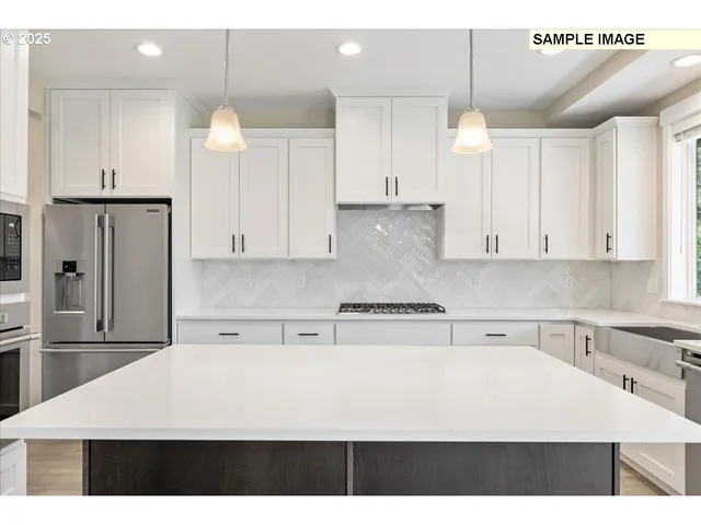 a view of a kitchen with refrigerator and windows