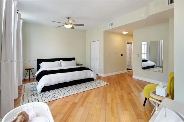 a bedroom with a bed and wooden floor