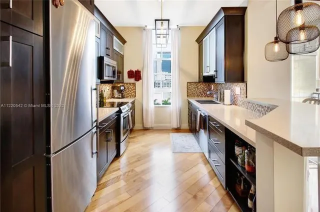 a kitchen with stainless steel appliances granite countertop a refrigerator and a stove