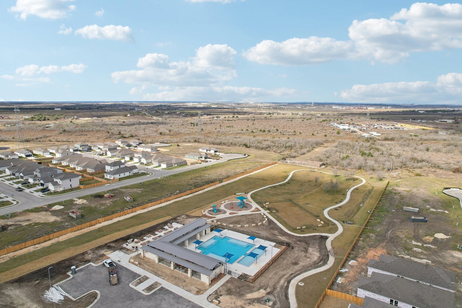 13500 Derby Ride Drive Buda, TX 78610 - Photo 7 of 7 An aerial view showcases community amenities including a swimming pool, playground, and walking trails.