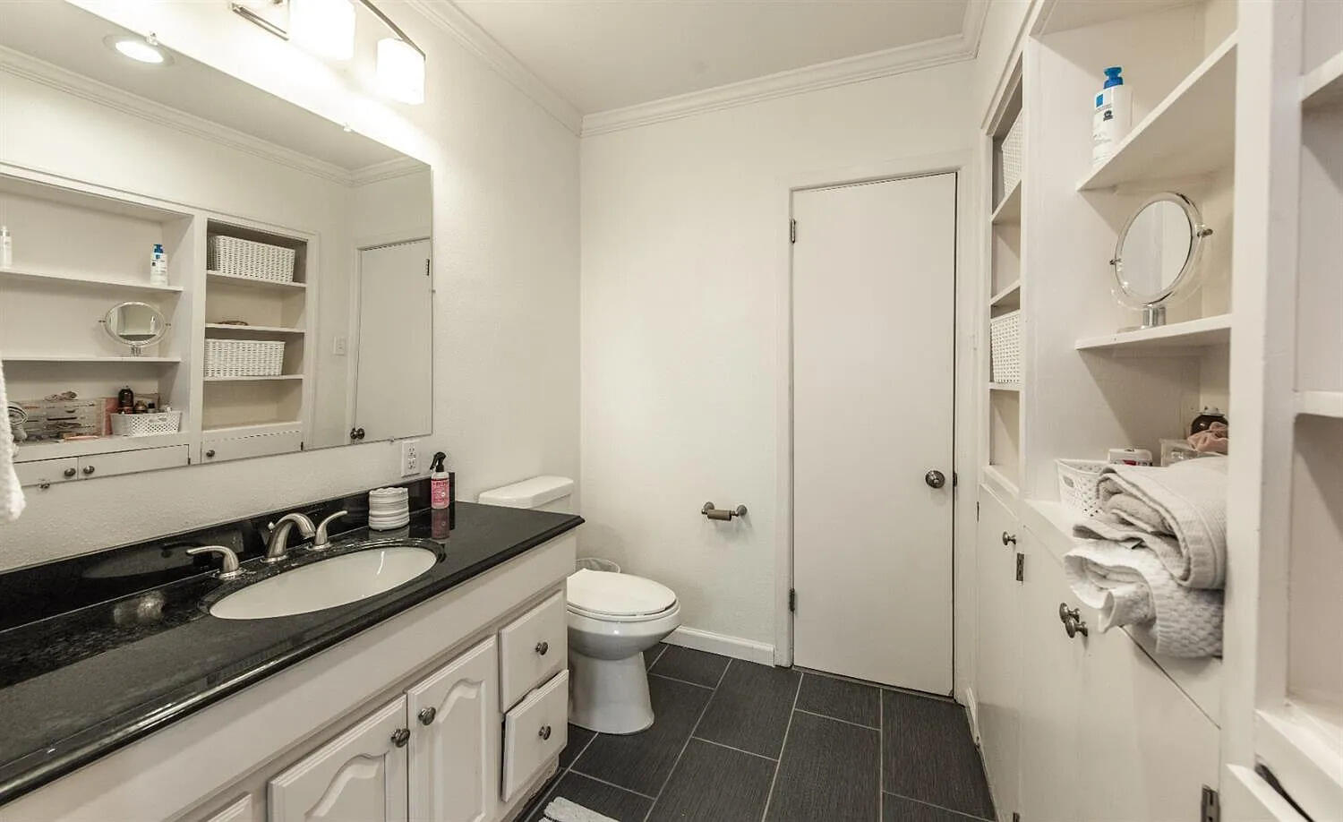 3105 29th Street Lubbock, TX 79410 - Photo 15 of 18 a bathroom with a granite countertop sink and a mirror