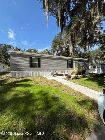 a front view of house with yard and trees