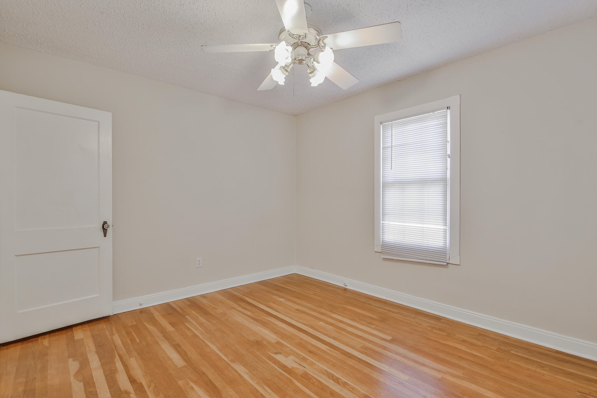 2715 29th Street Lubbock, TX 79410 - Photo 12 of 35 wooden floor in an empty room with a window