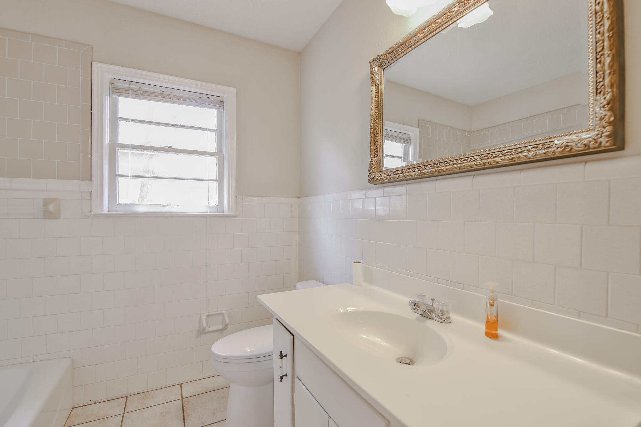 2715 29th Street Lubbock, TX 79410 - Photo 13 of 35 a bathroom with a sink a toilet and mirror