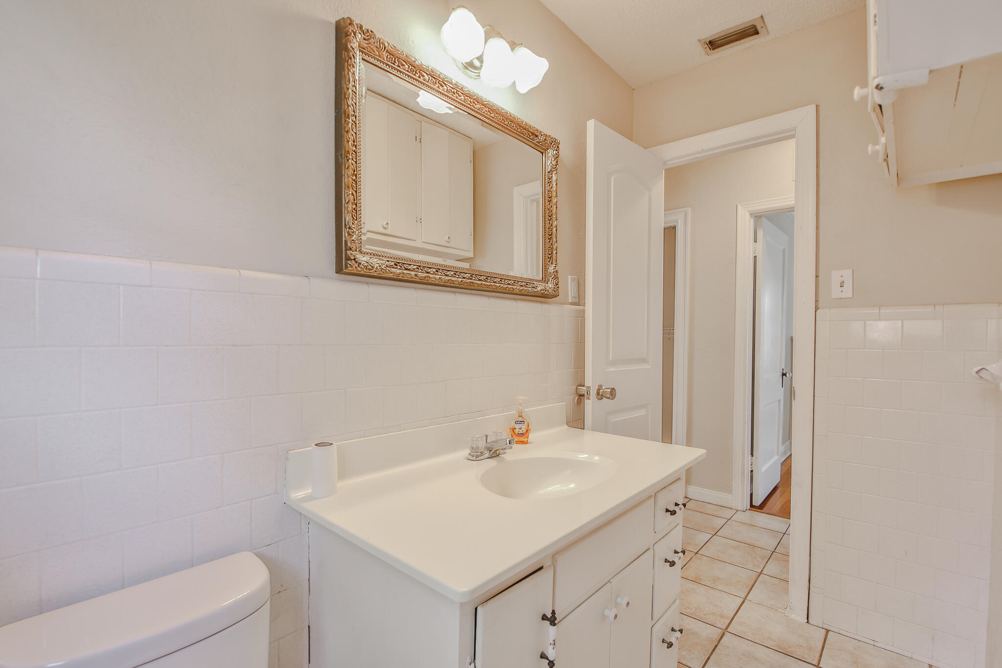 2715 29th Street Lubbock, TX 79410 - Photo 14 of 35 a bathroom with a sink a toilet and mirror