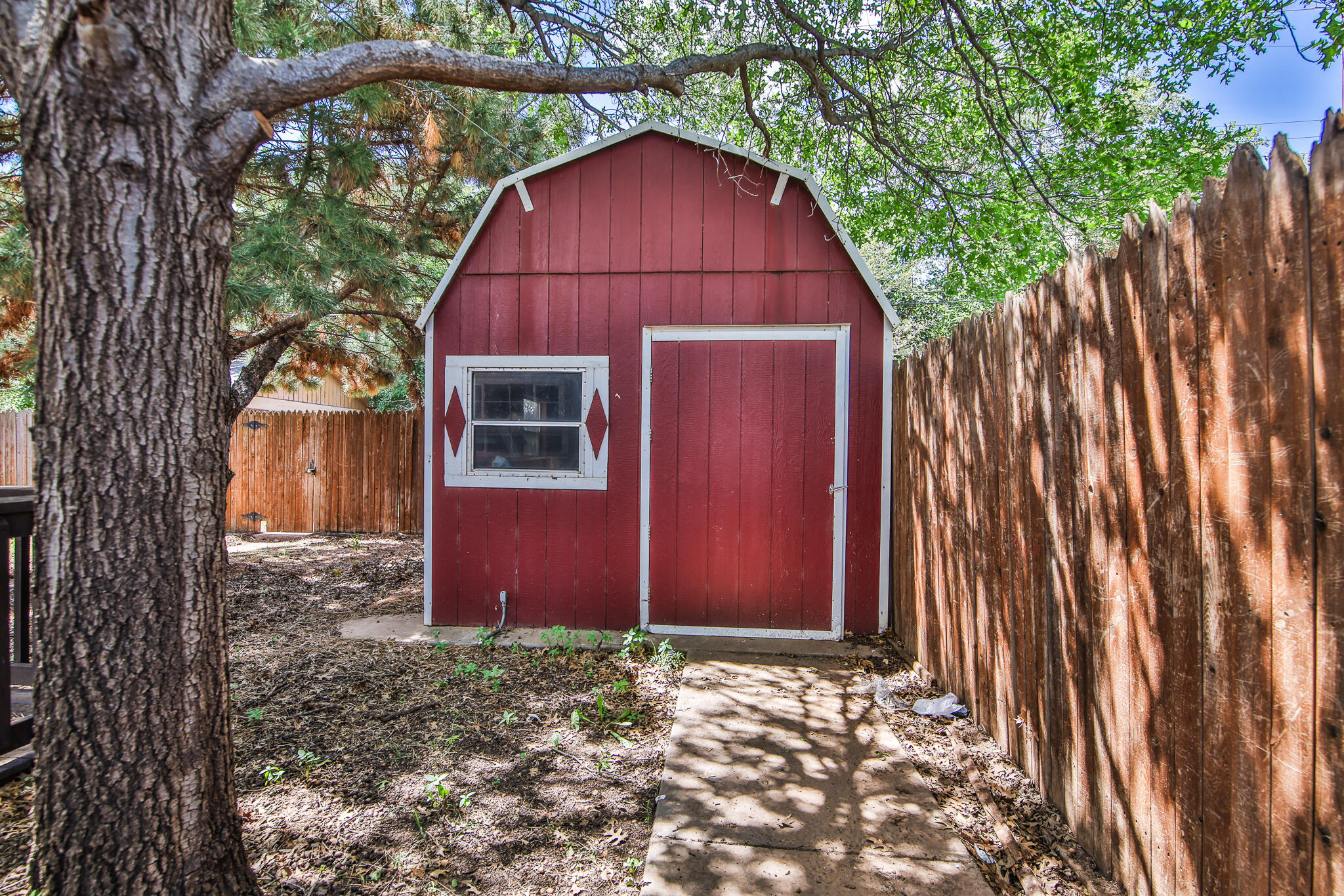 2715 29th Street Lubbock, TX 79410 - Photo 31 of 35 a view of a barn in the yard with wooden fence