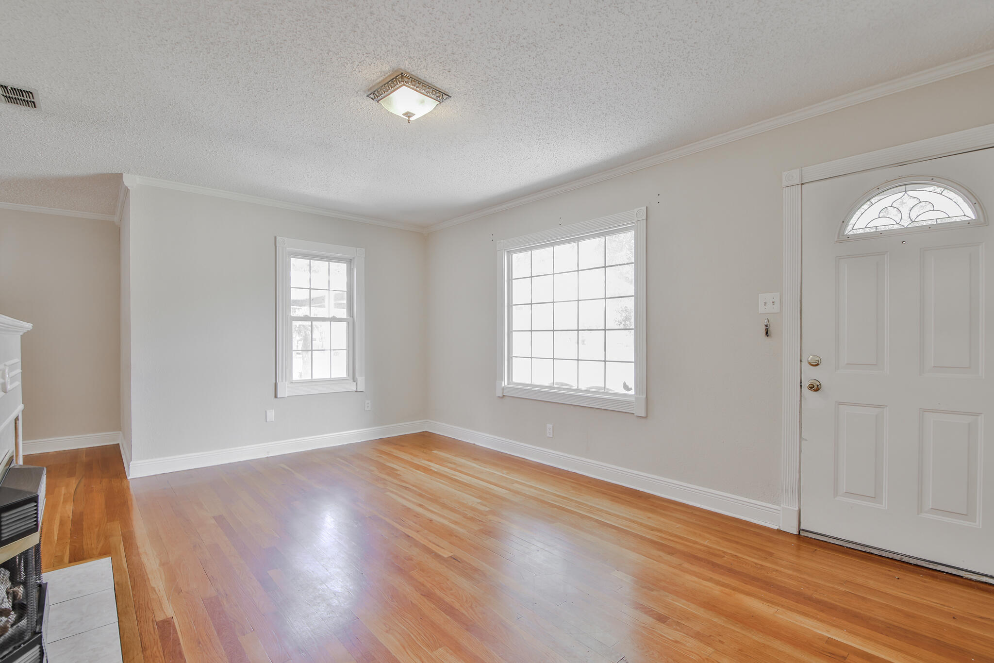 2715 29th Street Lubbock, TX 79410 - Photo 5 of 35 an empty room with wooden floor and windows