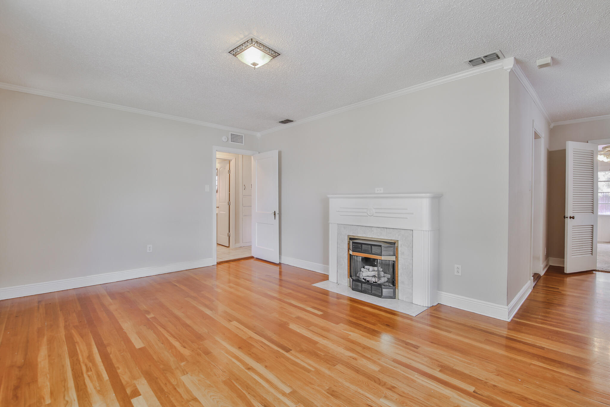2715 29th Street Lubbock, TX 79410 - Photo 6 of 35 a view of an empty room with wooden floor fireplace and a window