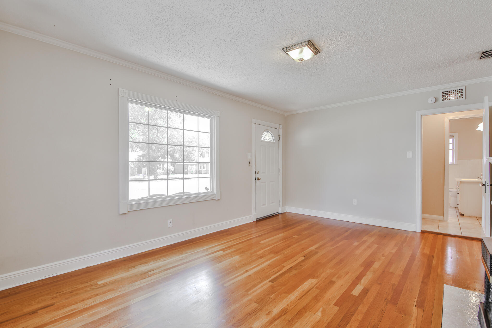 2715 29th Street Lubbock, TX 79410 - Photo 7 of 35 an empty room with wooden floor and windows