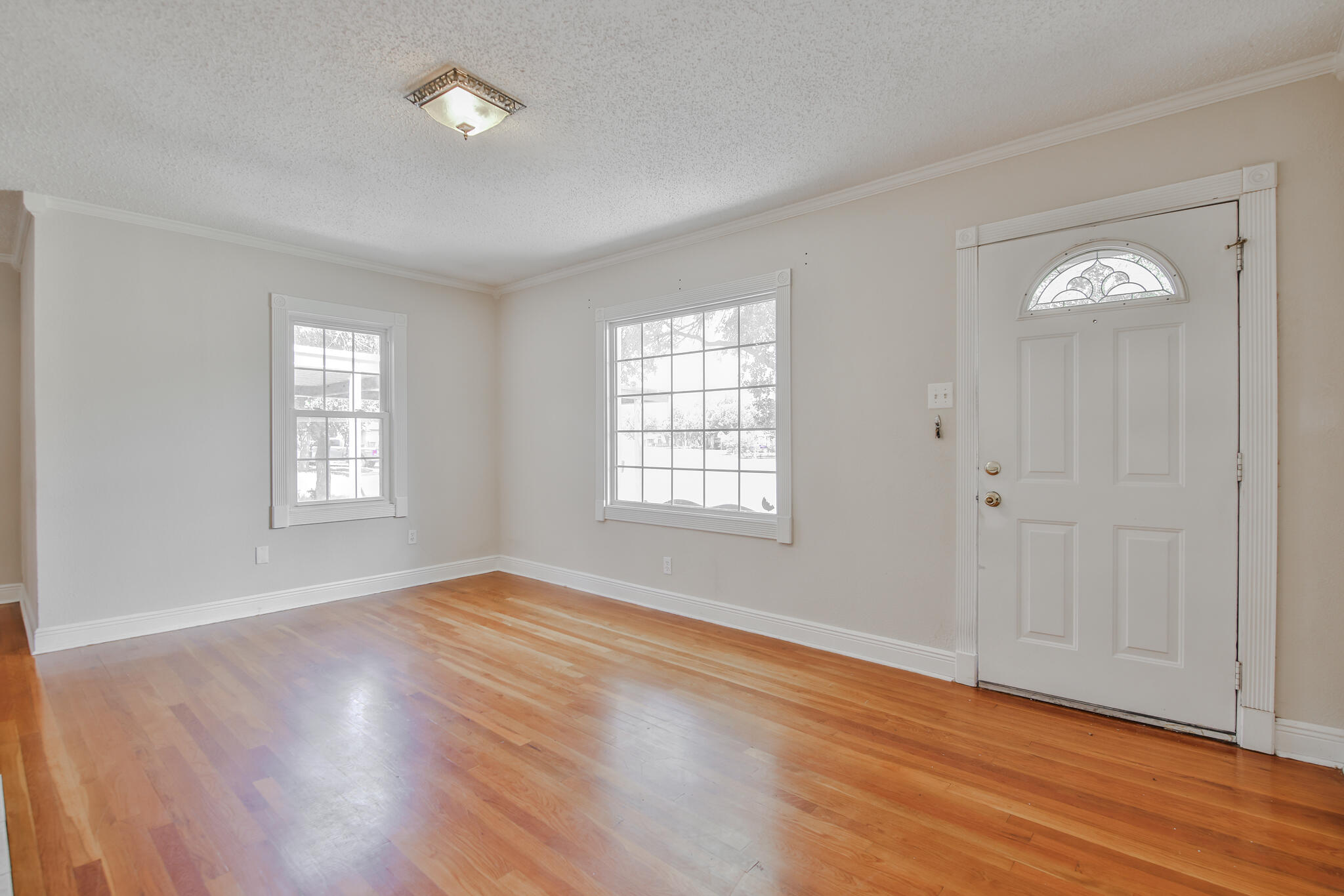 2715 29th Street Lubbock, TX 79410 - Photo 8 of 35 a view of an empty room with wooden floor and a window