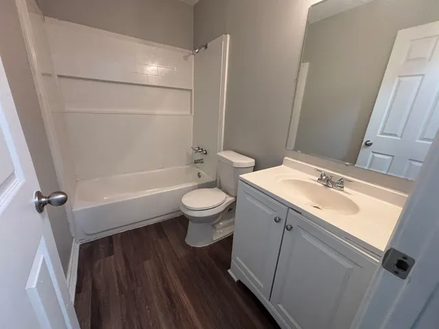 a bathroom with a toilet a sink a mirror and shower