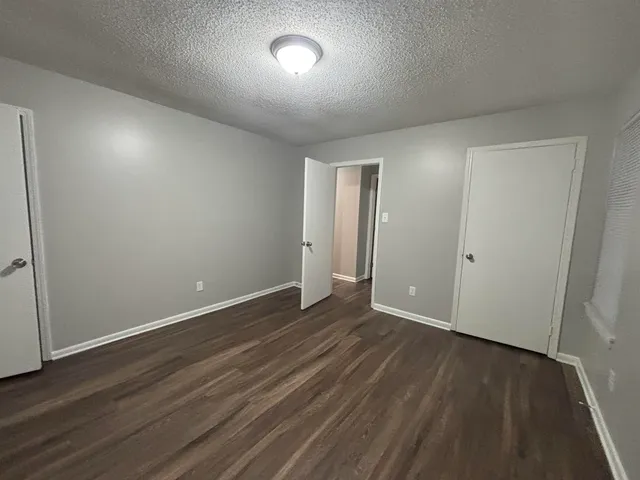 a white toilet sitting next to a white wall