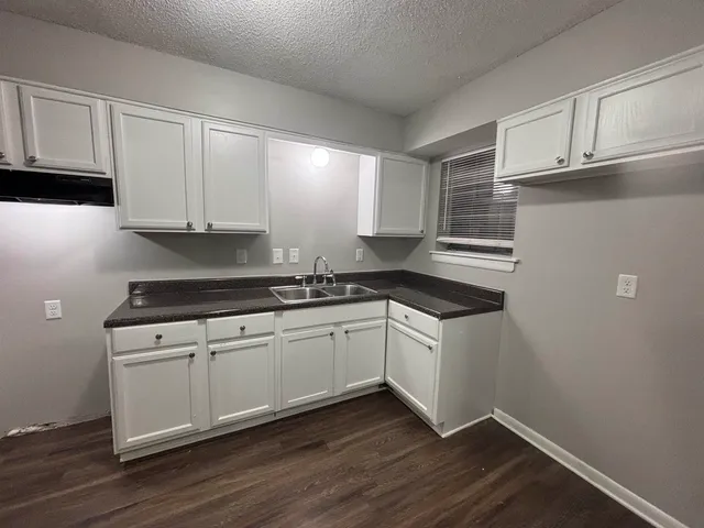 a kitchen with granite countertop cabinets stainless steel appliances and a sink