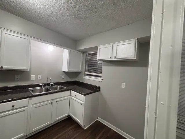 a kitchen with cabinets appliances and a window