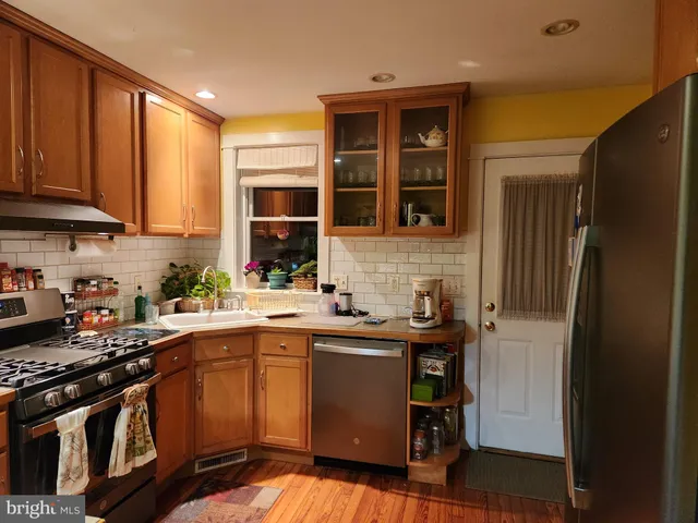 a bedroom with a bed a desk and chair with wooden floor
