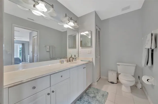 a bedroom with a bed a mirror on the dresser and a table