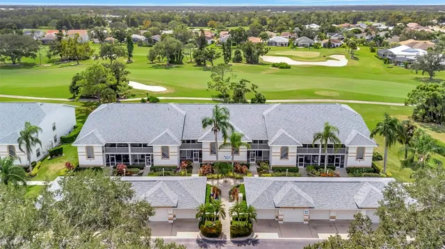 an aerial view of residential houses with outdoor space and parking