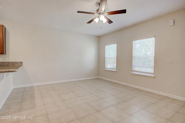 an empty room with windows and fan
