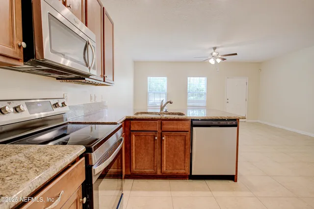 a kitchen with stainless steel appliances granite countertop a sink and a stove
