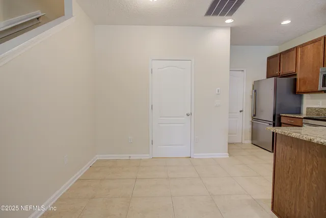 a view of a refrigerator in kitchen and a window