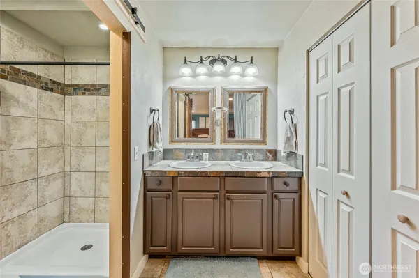 a bathroom with a tub sink shower and mirror