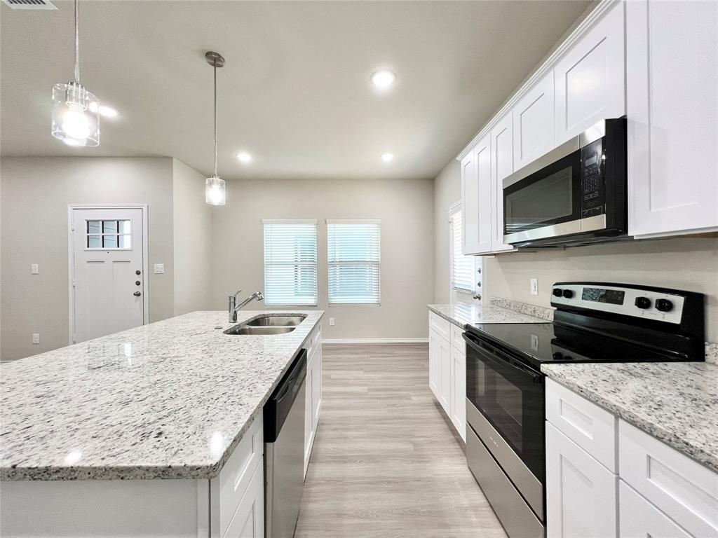3501 East Renfro Street, Unit 201 Burleson, TX 76028 - Photo 5 of 33 a kitchen with stainless steel appliances granite countertop wooden cabinets and granite counter tops