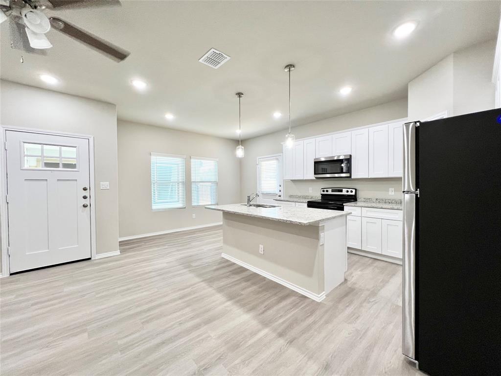 3501 East Renfro Street, Unit 201 Burleson, TX 76028 - Photo 7 of 33 a kitchen with white cabinets and stainless steel appliances