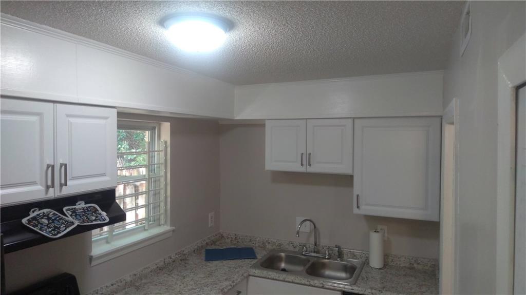 4701 Flat Shoals Road Union City, GA 30291 - Photo 4 of 23 a kitchen with white cabinets a window and a sink