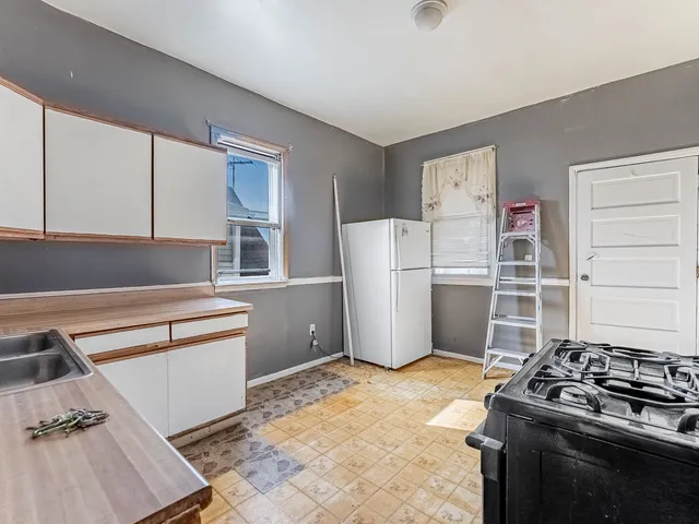 a kitchen with a refrigerator and white cabinets
