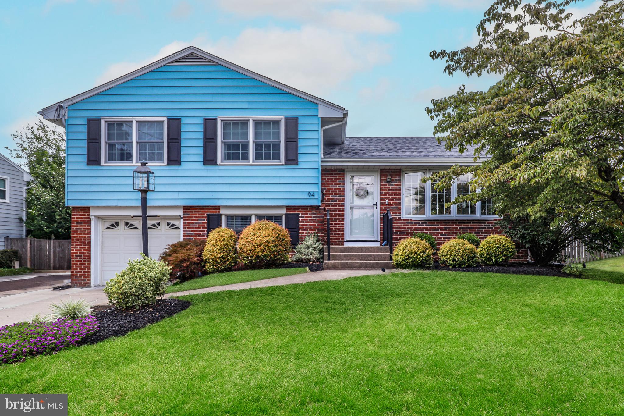 a view of a house with a yard and potted plants
