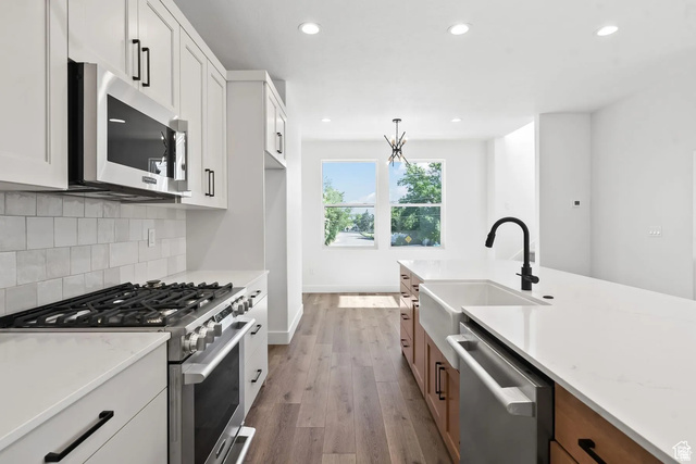545 East 7215 South Midvale, UT 84047 - Photo 6 of 27 Kitchen featuring stainless steel appliances, dual tone cabinets, dark wood-style floors, decorative backsplash, and decorative light fixtures