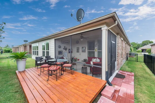 a view of a patio with table and chairs potted plants with wooden floor and fence