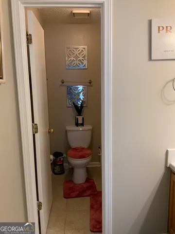 a bathroom with a toilet and a painting on the wall