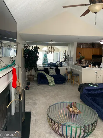 a living room with furniture a flat screen tv and a large window