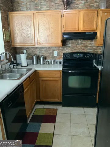 a kitchen with a stove a sink and a microwave