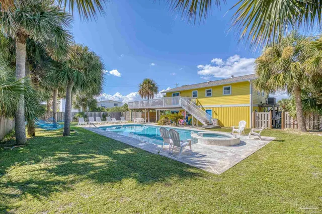 a view of a house with backyard and sitting area