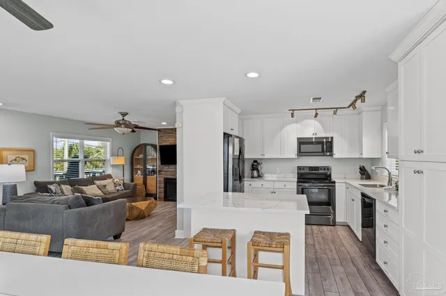 a kitchen with granite countertop a sink cabinets window and stainless steel appliances