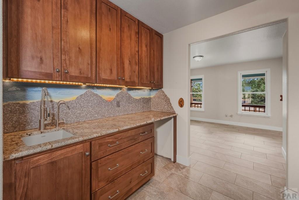23360 Monarch Road Aguilar, CO 81020 - Photo 12 of 52 a kitchen with granite countertop wooden cabinets a sink and dishwasher