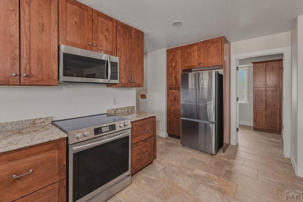 23360 Monarch Road Aguilar, CO 81020 - Photo 3 of 52 a kitchen with stainless steel appliances granite countertop a stove microwave and refrigerator
