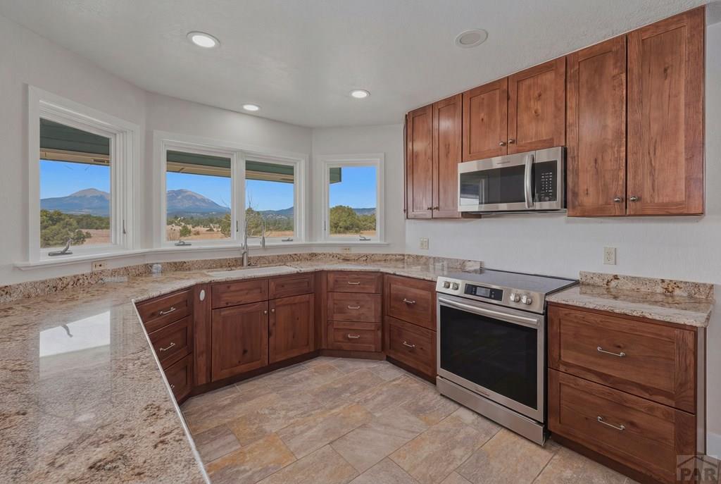 23360 Monarch Road Aguilar, CO 81020 - Photo 4 of 52 a kitchen with stainless steel appliances granite countertop wooden cabinets stove top oven and sink