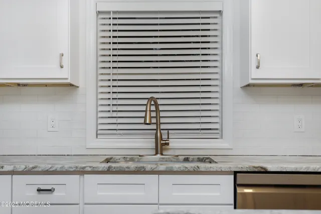 a kitchen with granite countertop white cabinets and white appliances